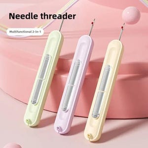 May include: Three multifunctional 2-in-1 needle threaders in light green, lavender, and pale yellow. Each tool features a slender, elongated body with a central metallic sliding mechanism and a thin wire hook at the top for threading needles.