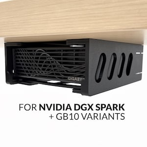 Könnte beinhalten: Eine schwarze Untertisch-Halterung, die eine Computerkomponente mit sichtbarem Lüftergitter und dem Schriftzug GIGABYTE hält. Unter der Halterung steht der Text FOR NVIDIA DGX SPARK + GB10 VARIANTS. Die Halterung ist an der Unterseite einer hellen Holzfläche befestigt.
