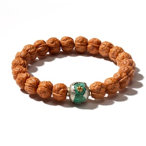 May include: A bracelet composed of numerous small, brown, textured, spherical beads resembling miniature walnuts. A single, larger, central bead features a silver-toned metallic finish with a vibrant green, cratered texture and a small gold-colored accent.