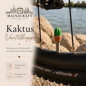 Könnte beinhalten: Eine grüne kaktusförmige Ventilkappe mit einem braunen Topfsockel, die auf einem Fahrradventil montiert ist. Das Bild enthält den Text MAINZCRAFT, Kaktus Ventilkappe, Handgemacht. Detailverliebt. Ein Hauch Sommer für dein Rad, Einzigartiges Design.