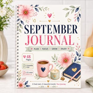 Könnte beinhalten: Ein spiralgebundenes September-Journal mit weißem Einband, rosa Blumenillustrationen, goldenen Herzen und dem Text "SEPTEMBER JOURNAL" in Marineblau und Pink. Es enthält 48 Seiten, ein druckbares PDF-Format und Maße von 21,59 x 27,94 cm.