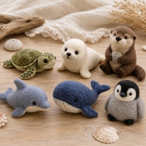 Könnte beinhalten: Eine Sammlung von sechs nadelgefilzten Tierfiguren, bestehend aus einer grünen Meeresschildkröte, einem weißen Robbenbaby, einem braunen Otter mit Stein, einem blauen Delfin, einem dunkelblauen Wal und einem grauen Pinguinküken.