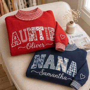 May include: A red sweatshirt with a red and white gingham collar and cuffs, featuring the word AUNTIE in patterned block letters and the name Oliver embroidered below. A navy blue sweatshirt with a navy gingham collar and cuffs, featuring the word NANA in patterned block letters and the name Samantha embroidered below.