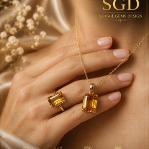 Puede incluir: Un collar de oro y un anillo de oro a juego, ambos con una piedra preciosa de citrino amarillo rectangular de corte esmeralda. El conjunto de joyas lleva el texto SGD SOHAIL GEMS DESIGN. Las piezas se muestran juntas, destacando las piedras de color amarillo dorado claro engastadas en monturas de oro pulido.