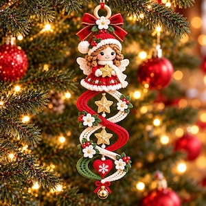 May include: A crocheted Christmas ornament featuring a doll with brown hair wearing a red and white hat and dress, holding a gold star. Below the doll, a spiral design includes two gold stars, a red heart with a white snowflake, and a gold bell.