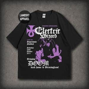 Könnte beinhalten: Ein schwarzes Kurzarm-T-Shirt mit einem violetten und weißen Grafikdruck. Das Design enthält den Text Electric Wizard, Capsule Presents, Supersonic Festival, Saturday 22nd October 2011, Bringing DOOM back home to Birmingham und Lambsky Apparel.