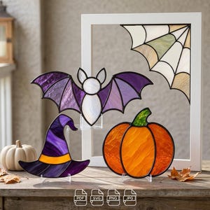 May include: Stained glass decorations featuring a purple bat, a purple and orange witch hat, an orange pumpkin with a green stem, and a spider web corner piece. The items are displayed with a white frame and include PDF, SVG, PNG, and JPG icons.