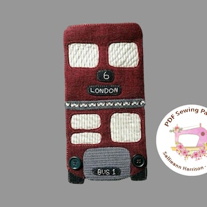 May include: A red felt London double-decker bus with white windows and the number 6 on the front. The bus says "LONDON" and "BUS 1" on the front. The bus is a sewing pattern.