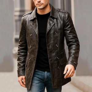 May include: A dark brown leather double-breasted coat featuring a wide collar, shoulder epaulets, and two rows of buttons. The coat includes long sleeves with buttoned cuffs and two front flap pockets, worn over a black shirt and blue jeans.
