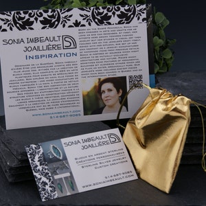 May include: Two business cards for Sonia Imbeault Joailliere, a jewellery designer. The cards are on a black slate surface with a gold pouch. The text on the cards reads "Sonia Imbeault Joailliere" and "Bijoux en Argent Sterling Creations Personnalisees Sterling Silver Jewellery Custom Creations". The website address and phone number are also included on the cards.