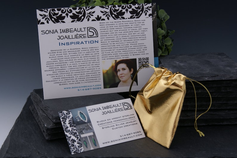 May include: Two business cards for Sonia Imbeault Joailliere, a jewellery designer. The cards are on a black slate surface with a gold pouch. The text on the cards reads "Sonia Imbeault Joailliere" and "Bijoux en Argent Sterling Creations Personnalisees Sterling Silver Jewellery Custom Creations". The website address and phone number are also included on the cards.