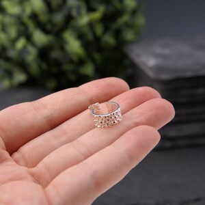 May include: A silver ear cuff with a textured, bumpy surface. The cuff is open and ready to be worn.