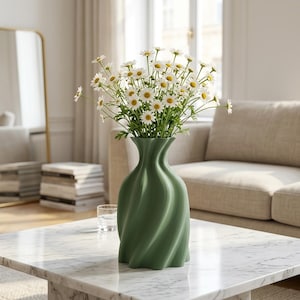 Può includere: Un vaso verde salvia con una texture verticale a spirale e un collo stretto, riempito con un grande bouquet di margherite bianche con centri gialli. Il vaso ha una finitura opaca liscia e una base ampia e arrotondata che si restringe verso l'alto.