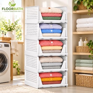 May include: A white plastic modular storage unit with five stacked open-front bins, each containing folded sweaters in various colors including pink, blue, yellow, and gray. The unit features a perforated side design.