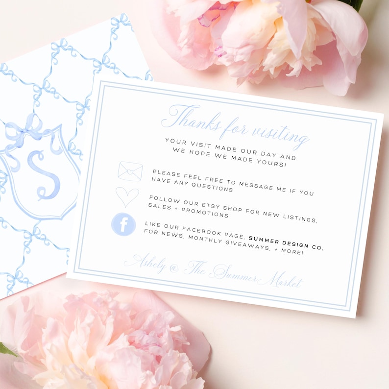 May include: A white card with light blue text and a light blue border. The card reads "Thanks for visiting" and includes contact information. A second card with a light blue bow pattern is visible. Pink flowers are in the background.