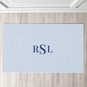 May include: A light blue doormat with a white geometric pattern and the monogram "RSL" in navy blue.