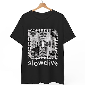 Puede incluir: Una camiseta negra de manga corta con un estampado gráfico blanco de un patrón de laberinto complejo con una figura central. La palabra slowdive está impresa en letras minúsculas blancas debajo del diseño del laberinto.
