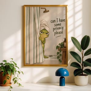Pode incluir: Uma impressão de arte emoldurada com um sapo verde usando uma toalha branca na cabeça, espreitando por trás de uma cortina de chuveiro listrada. O texto diz, can I have some privacy please. A cena inclui um chuveiro e uma pequena planta.