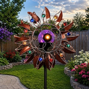 May include: A copper-colored metal wind spinner featuring a central glowing purple glass orb and radiating leaf-shaped petals. Each petal is accented with a small, colorful translucent gem in shades of red, blue, green, and amber.
