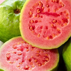 May include: A group of guavas featuring one whole fruit with a smooth light green skin and two halved fruits displaying a vibrant pink interior flesh filled with small, light-colored seeds. The texture of the fruit flesh appears moist and dense.
