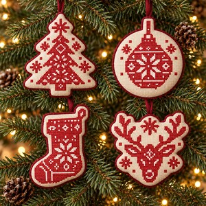 May include: Four hanging ornaments featuring red and cream cross-stitch patterns. The shapes include a Christmas tree, a circular bauble, a stocking, and a reindeer head, each suspended by a thin red ribbon against a pine tree background.
