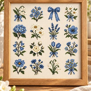 May include: A framed cross-stitch sampler featuring a grid of sixteen individual botanical motifs, including various blue and white flowers, sprigs of greenery, and a central blue ribbon bow, all stitched on a light cream-colored fabric background.