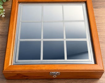 May include: A rectangular wooden display box with a natural light brown finish, featuring a clear glass lid and a silver metal latch. The interior is divided into nine equal square compartments by thin white dividers, creating a grid pattern.