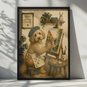 Puede incluir: Una impresión artística enmarcada que muestra a un perro golden doodle con una boina azul y un delantal manchado de pintura, sentado en un taburete mientras pinta un paisaje en un caballete. La pared muestra un letrero con el texto CREATE EXPLORE INSPIRE.