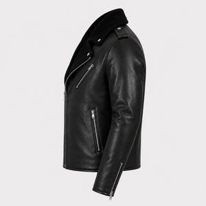 May include: A black leather motorcycle jacket featuring a wide collar, silver-toned metal zippers on the front, side pockets, and cuffs. The jacket has a structured silhouette with epaulets on the shoulders and a smooth, matte-textured finish.