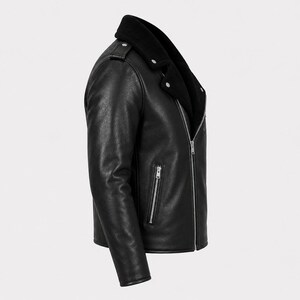 May include: A black leather motorcycle jacket featuring a wide collar, silver-toned metal zippers on the front and side pockets, shoulder epaulets with silver snaps, and long sleeves. The jacket is shown from a side profile view against a plain background.
