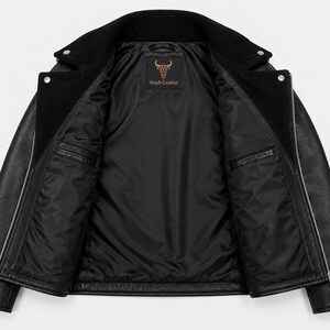 May include: A black leather jacket with a wide collar, silver-toned metal zippers, and a smooth black interior lining. The inner label features a bull head logo and the text "Vnudo Leather" printed in a copper-colored font on a black background.
