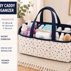 May include: A rectangular baby caddy organiser with a cream base featuring a blue moon and star pattern, navy blue trim, and handles. The caddy has internal dividers and contains various baby care items. Text indicates a finished size of 38 cm wide, 25.5 cm high, and 18 cm deep.