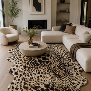 May include: An irregular, hide-shaped area rug featuring a dense leopard print pattern with black and dark brown spots on a cream-colored background. The rug has a soft, textured pile and follows a natural, organic contour along its edges.