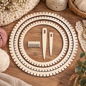 Può includere: Un set di tre telai circolari in legno con bordi dentellati, accompagnato da un piccolo pettine da tessitura in legno e due aghi in legno di diverse lunghezze, tutti caratterizzati da una finitura liscia in legno naturale chiaro.