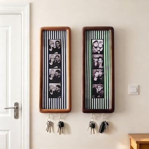 Puede incluir: Dos soportes de pared rectangulares de madera para llaves con esquinas redondeadas. El soporte izquierdo tiene un fondo de rayas azules y blancas, y el derecho uno de rayas verdes y blancas. Cada uno contiene una tira de fotos vertical.