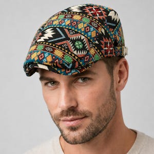 Könnte beinhalten: Eine Schiebermütze mit einem lebendigen, mehrfarbigen geometrischen Muster in Schwarz, Blau, Rot, Gelb und Grün. Die Mütze verfügt über einen strukturierten Schirm und einen verstellbaren seitlichen Riemen mit Metallschnalle.