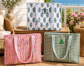 May include: Three rectangular quilted tote bags with two handles each. The top bag features a blue floral print on white with the monogram FBS. The bottom left bag has pink stripes and leopard print with monogram MA. The bottom right is green gingham with letter A.