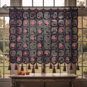 May include: A rectangular crochet wall hanging featuring a grid of dark purple and sage green squares. The design includes intricate spiderweb patterns, small pink floral motifs, and black bat accents. The bottom edge has purple tassels.