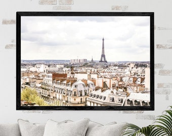 May include: A framed photograph of the Eiffel Tower in Paris, France. The photo shows a panoramic view of the city with rooftops and buildings in the foreground. The Eiffel Tower is in the background, with a cloudy sky above.
