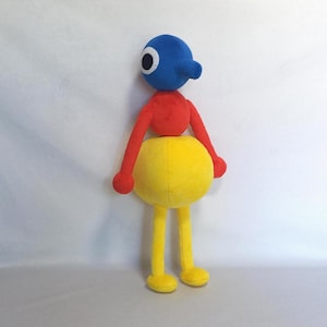 Puede incluir: Un juguete de peluche con una cabeza azul, una nariz larga y un ojo grande de color blanco y negro. El torso es rojo con brazos largos, mientras que la parte inferior es una esfera amarilla grande unida a dos piernas largas con pies amarillos.