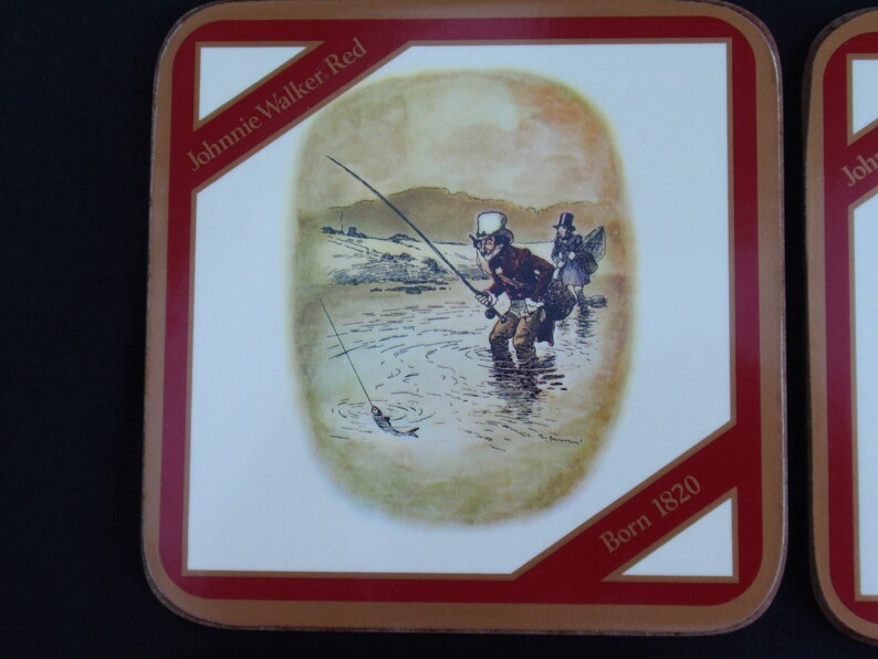 May include: A red and gold square coaster with a white center featuring a vintage illustration of two men fishing in a river. The text "Johnnie Walker Red" and "Born 1820" are printed on the coaster.