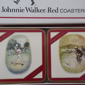 May include: Two square Johnnie Walker Red coasters with red borders. The coasters feature illustrations of a man playing cricket and a man fishing. Both coasters have the text "Born 1820" printed on them.