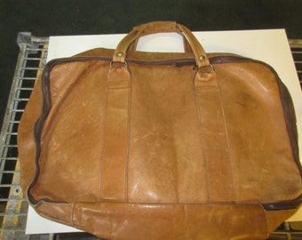 Soft leather two compartment travel bag with liner and heavy duty zippers.