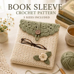 Puede incluir: Una funda de ganchillo para libros en color crema con una solapa festoneada en verde salvia, cierre de botón de madera y un bolsillo frontal. La funda incluye una pequeña flor y hoja tejidas. Texto: BOOK SLEEVE CROCHET PATTERN 3 SIZES INCLUDED.