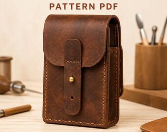 Puede incluir: Una riñonera de cuero marrón con cierre de solapa, un solo cierre de botón de latón y costuras visibles. El texto LEATHER BELT POUCH PATTERN PDF e INSTANT DIGITAL DOWNLOAD aparece en letras de color marrón oscuro sobre un fondo claro.