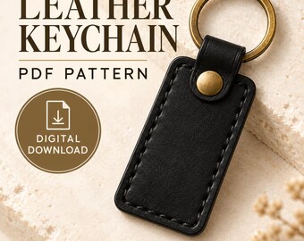 Puede incluir: Un llavero rectangular de cuero negro con costuras visibles y una anilla y remache de metal color latón. La imagen incluye el texto LEATHER KEYCHAIN PDF PATTERN y DIGITAL DOWNLOAD. El texto inferior indica PDF PATTERN ONLY NO PHYSICAL ITEM.