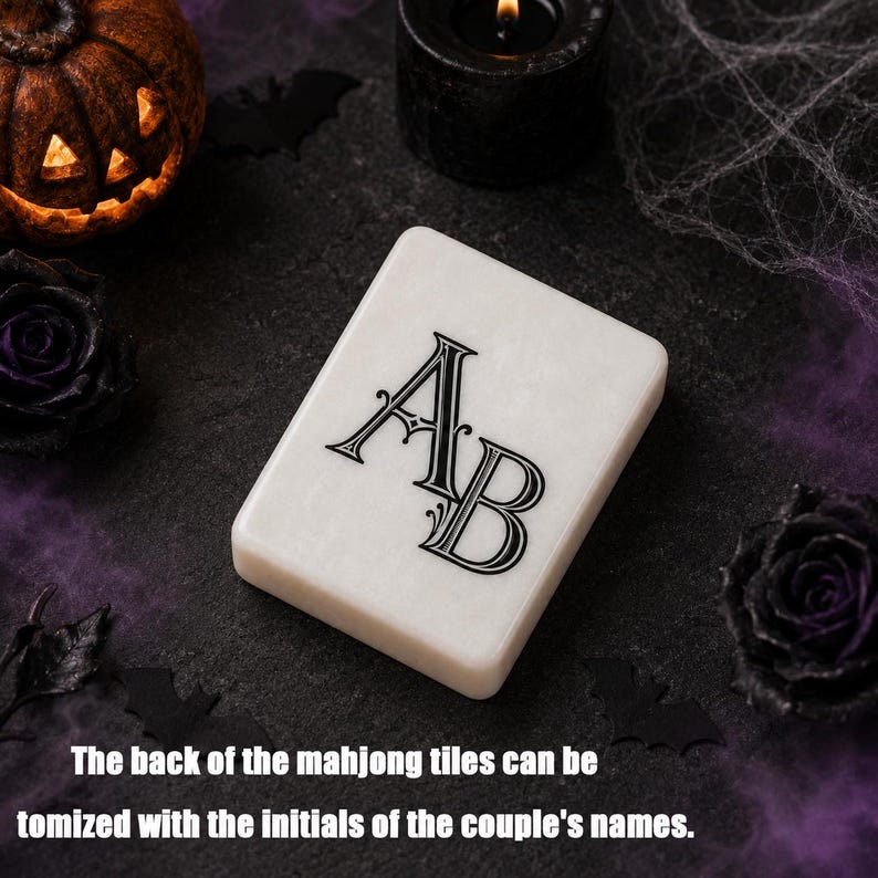May include: A rectangular white mahjong tile featuring the black printed initials AB in a decorative serif font. The tile has a smooth, polished surface and rounded corners, presenting a clean and distinct appearance for a personalized game piece.