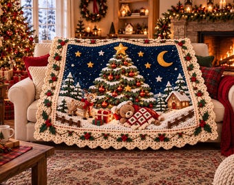 Puede incluir: Una manta de ganchillo rectangular que presenta un cielo nocturno azul oscuro con un árbol de Navidad central, una luna creciente y estrellas. La escena incluye un reno, un oso de peluche con una manta roja y blanca, y un borde color crema.