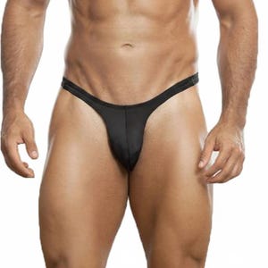 Puede incluir: Un tanga negro liso con un diseño minimalista, que presenta una cinturilla fina y una bolsa frontal contorneada. La prenda está confeccionada con un tejido suave y ligero que ofrece un ajuste ceñido y se asienta bajo en las caderas.