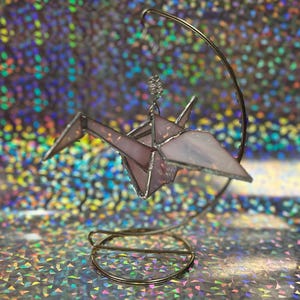 Gru di carta origami rosa sognante in vetro colorato